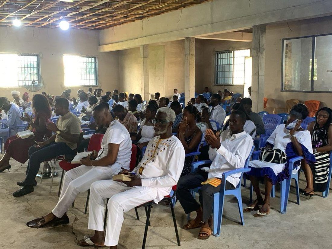 People seated together in the hall at Pool of Grace Church