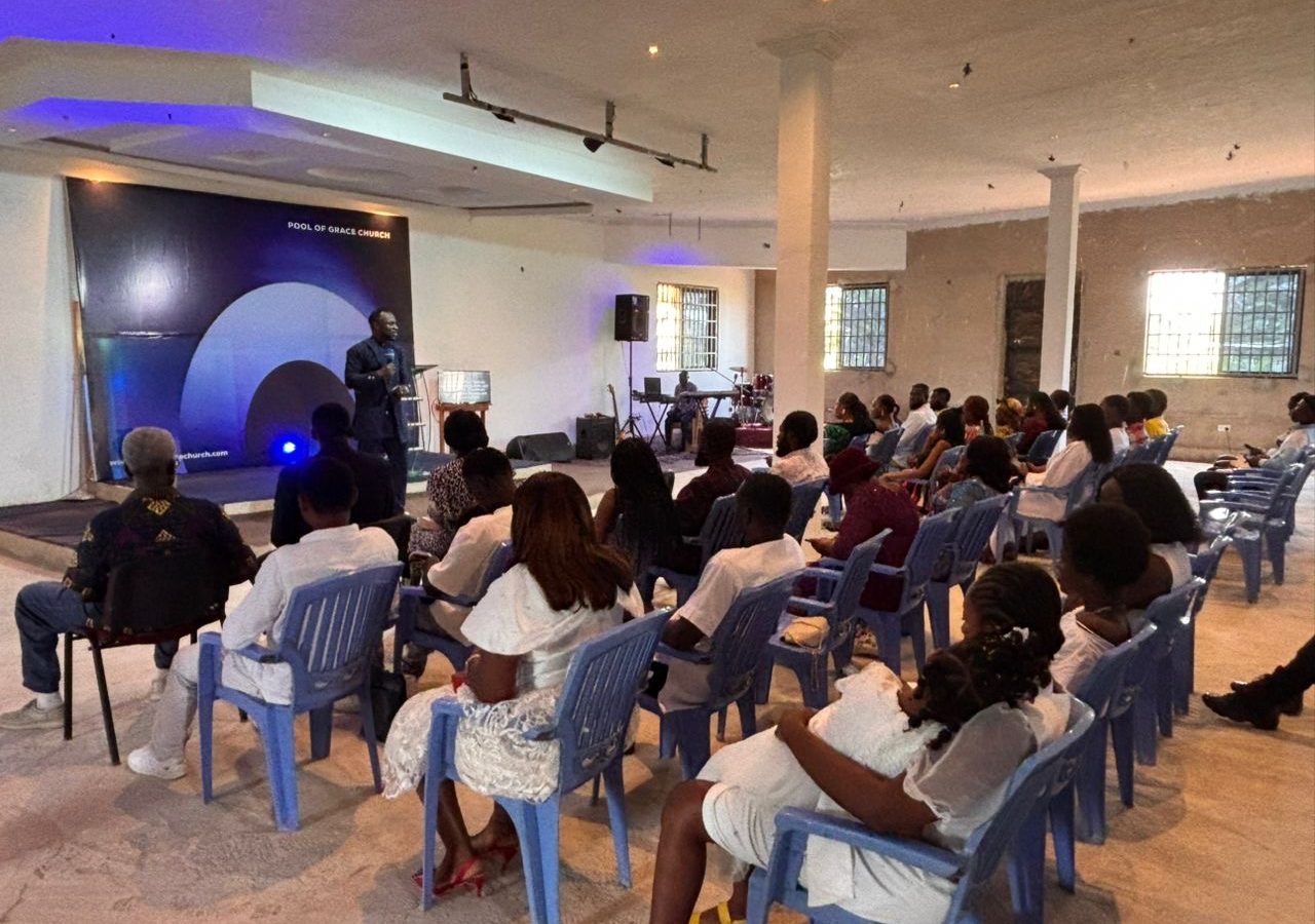 Sunday service at Pool of Grace Church: Rev. Fred A. Boateng preaching, the band playing, the hall full
